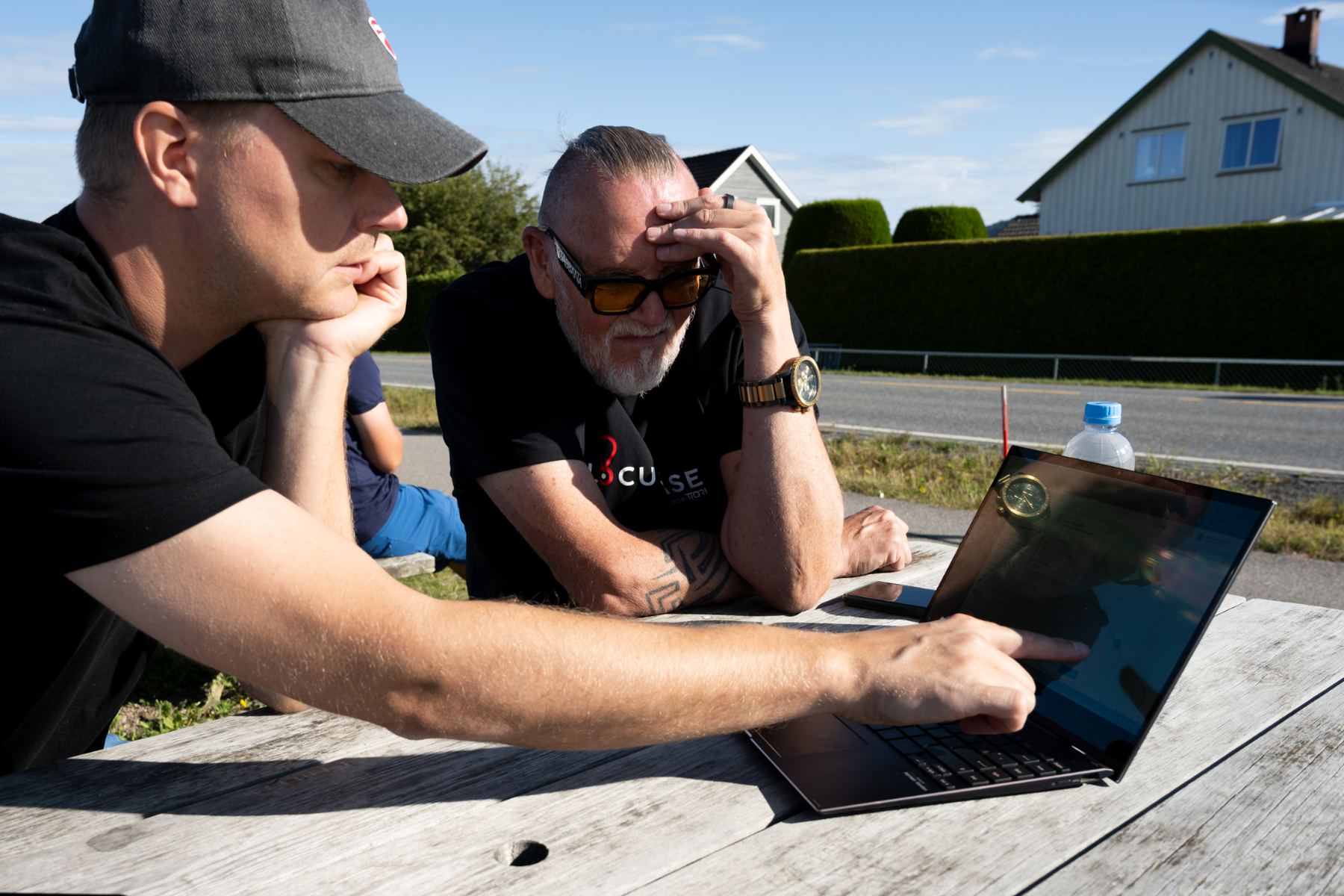 Race organisers reviewing the course on a laptop roadside